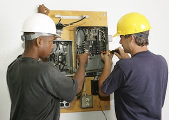 2 electrician working on electrical panel