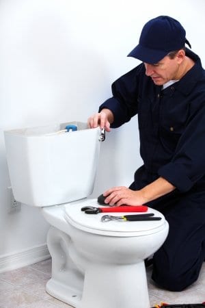 picture of man fixing a toilet