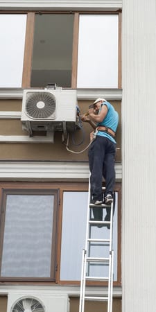 picture of man installing mini split air conditioner